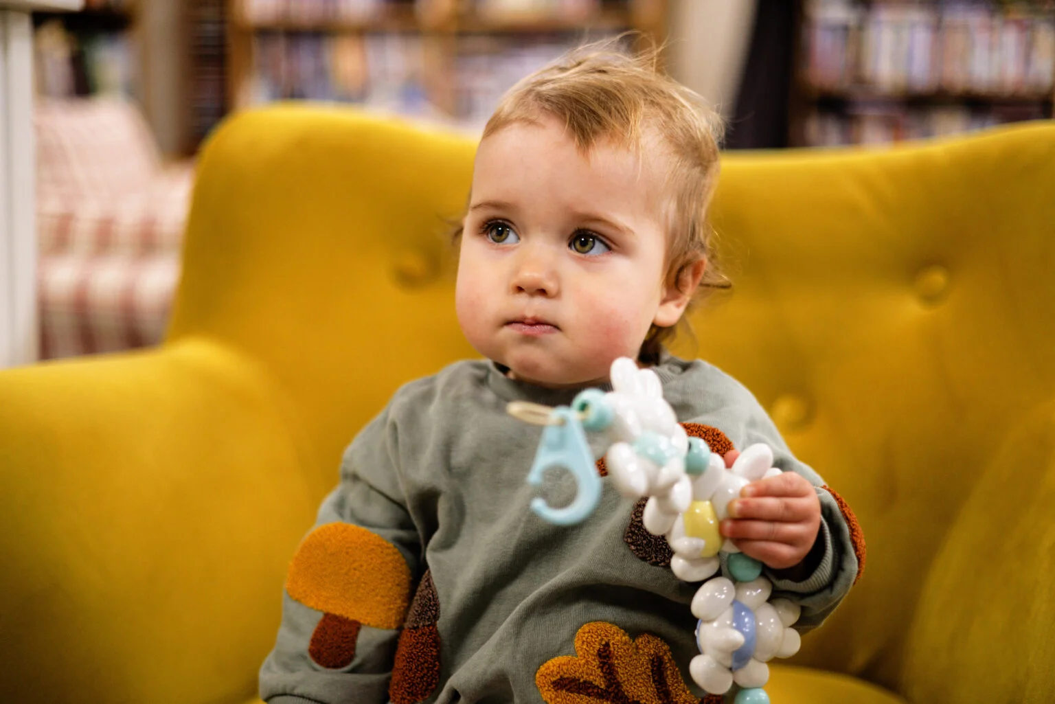 Baby sat on yellow chair with toy at New Starts